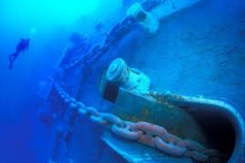 A submerged shipwreck with a large anchor and chain, surrounded by marine life. 5