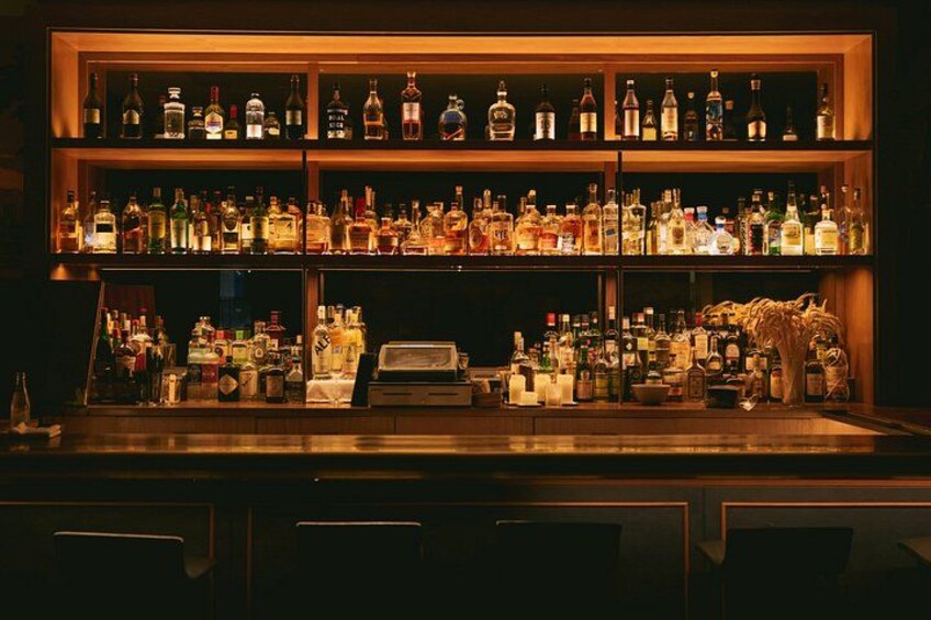 A bar with shelves of liquor bottles. 4
