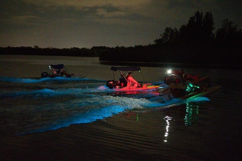 Three watercraft on a lake at night with artificial lighting. 4