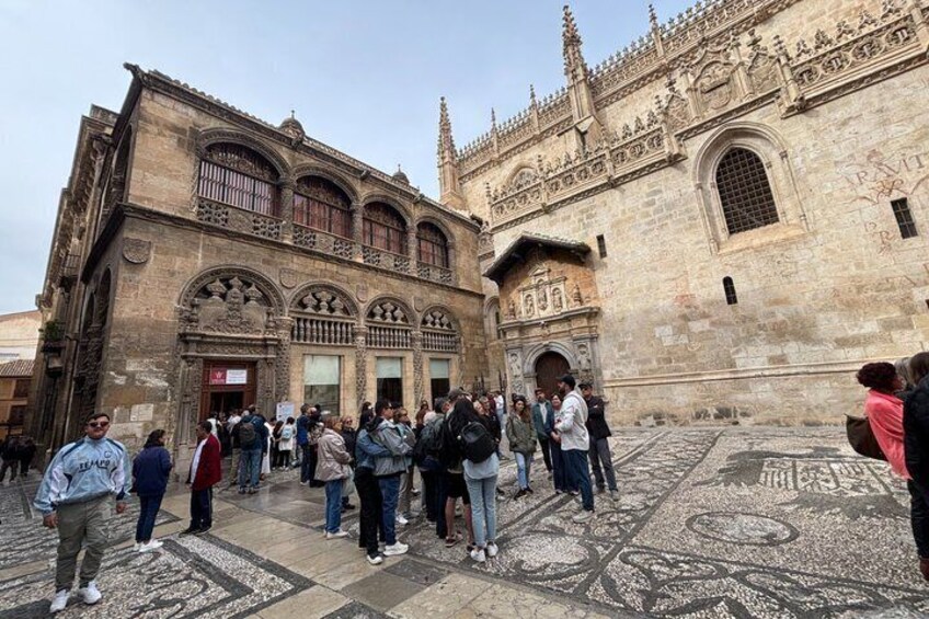 A historic building with intricate architecture and a crowd of people in front. 3
