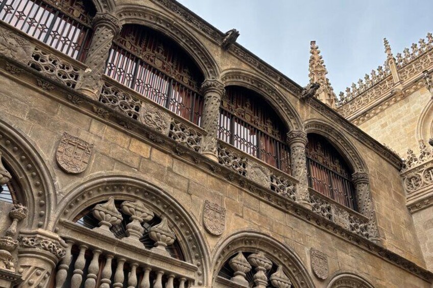 Ornate stone architecture with detailed carvings and arched windows. 1