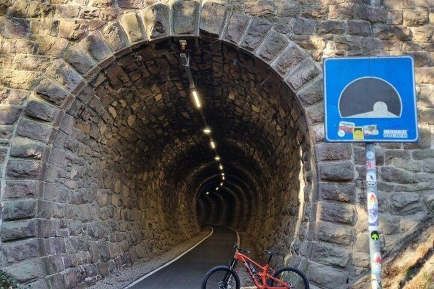 A stone tunnel with a bicycle parked at the entrance. 1