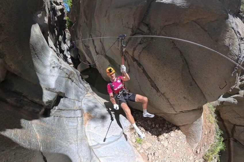 A person rappelling down a rocky cliff. 1