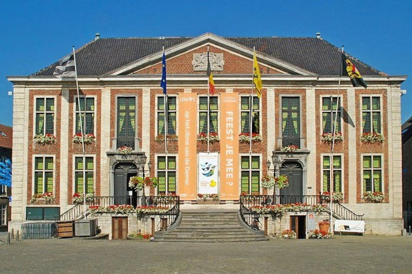 A large building with a symmetrical facade, multiple windows, and a central entrance with steps. 3