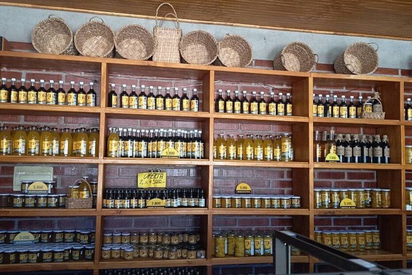 A wooden shelf with various bottles and baskets. 5