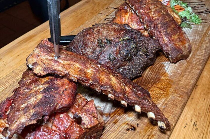 A wooden cutting board with cooked ribs and a meat thermometer. 4