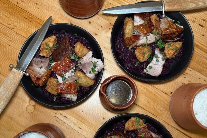 Two plates of food with meat and purple vegetables, a knife, and a bowl of rice. 5