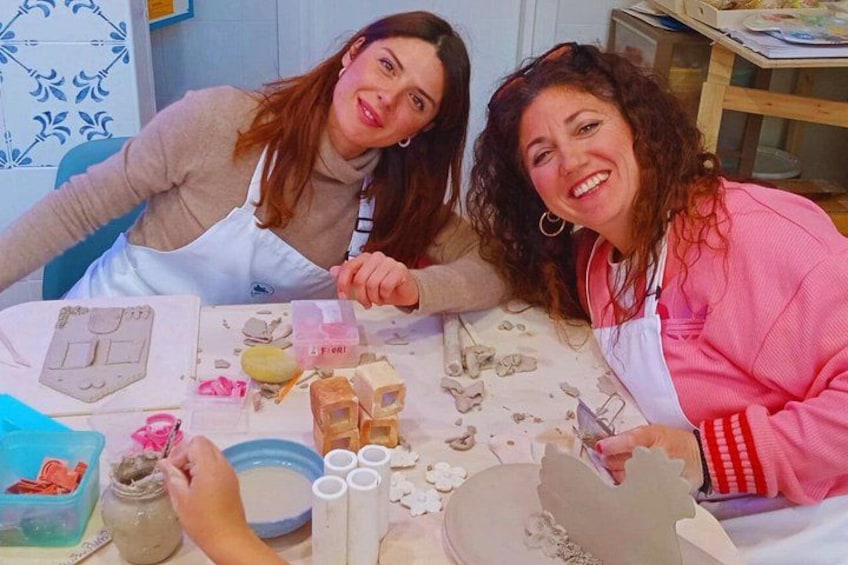 Two people engaged in pottery making with clay and tools on a table. 2