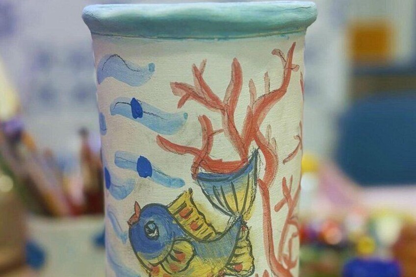A ceramic cup with a painted fish and coral. 5