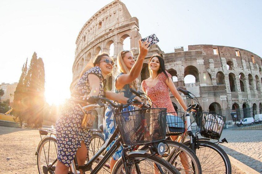 Trois personnes à vélo, avec un monument historique en arrière-plan. 3