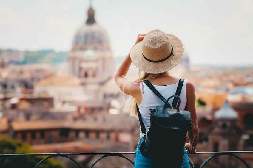 Une personne portant un chapeau de paille et un sac à dos, qui surplombe une ville avec un bâtiment imposant en forme de dôme. 4