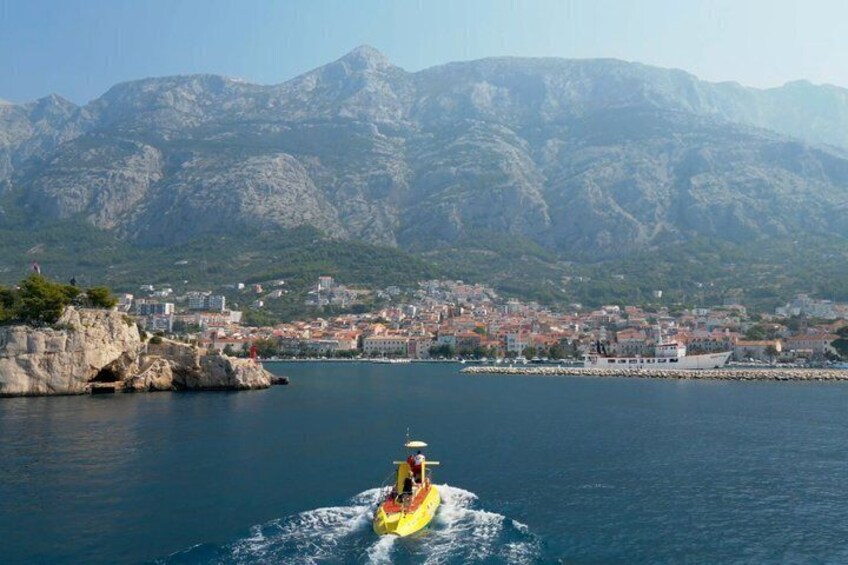 A yellow kayak on calm water with a mountainous backdrop. 3