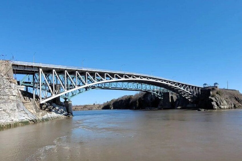 A steel bridge over a river with rocky banks. 3