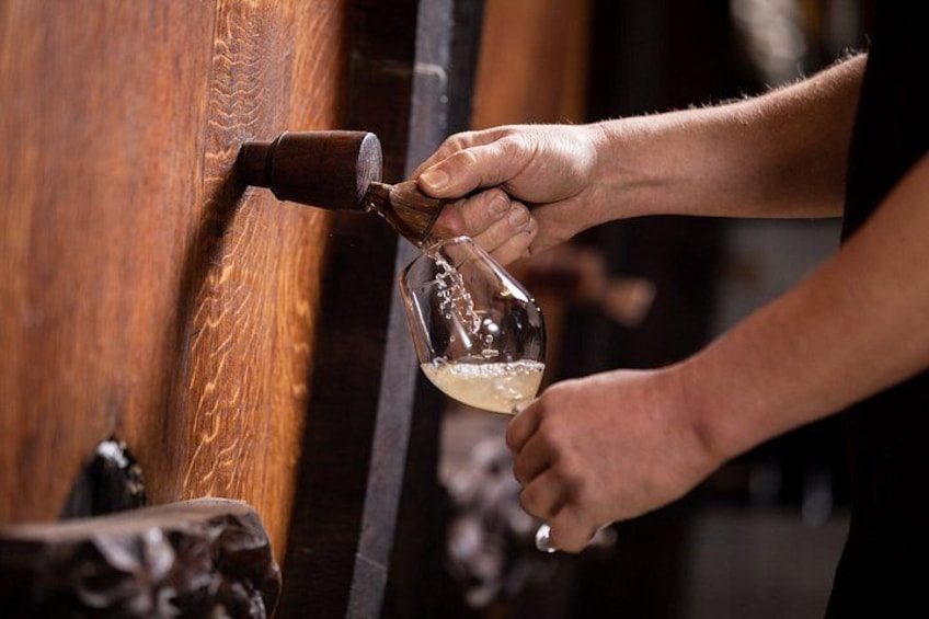A person pouring a liquid from a bottle into a glass. 5