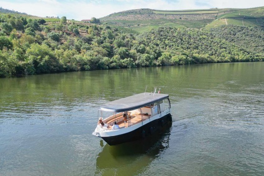 A boat on a calm river surrounded by lush greenery and hills. 1