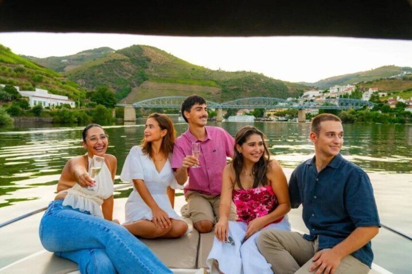 A group of people on a boat with a river and hills in the background. 4