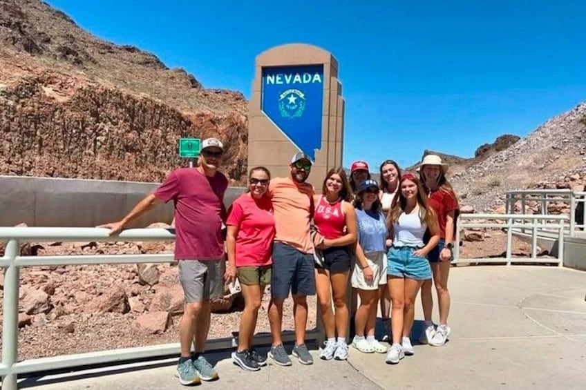 A group of people posing in front of a sign with the word 'NEVADA' on it. 5