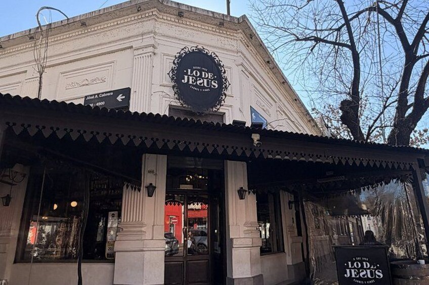 A building with a sign reading 'LODE JEESUS' and a storefront with a black awning. 1