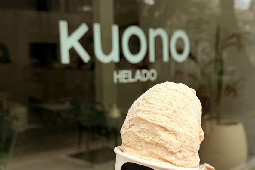 A scoop of ice cream in front of a glass window with the text 'kuono helado' visible. 5