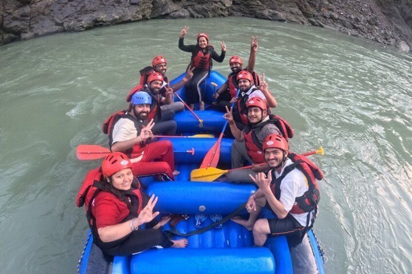 A group of people in a blue raft on a river. 5