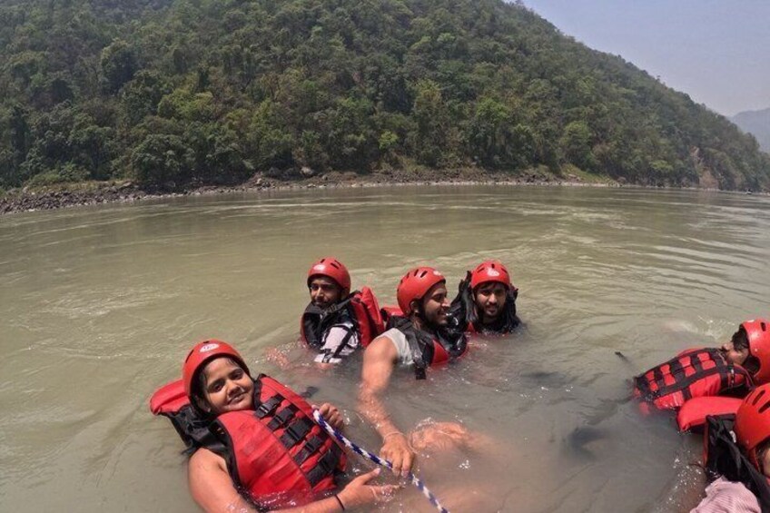 A group of people in a river wearing life jackets and helmets. 4