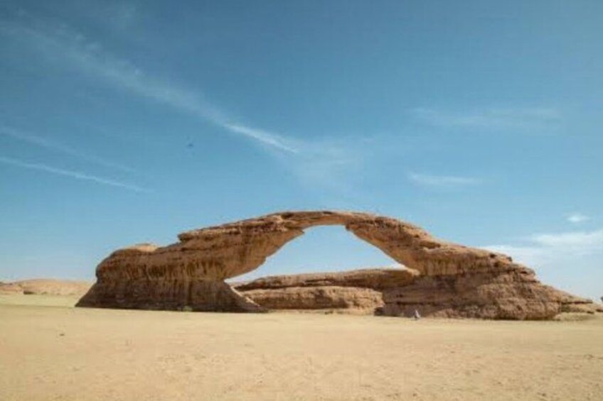 A natural rock arch formation in a desert landscape. 4