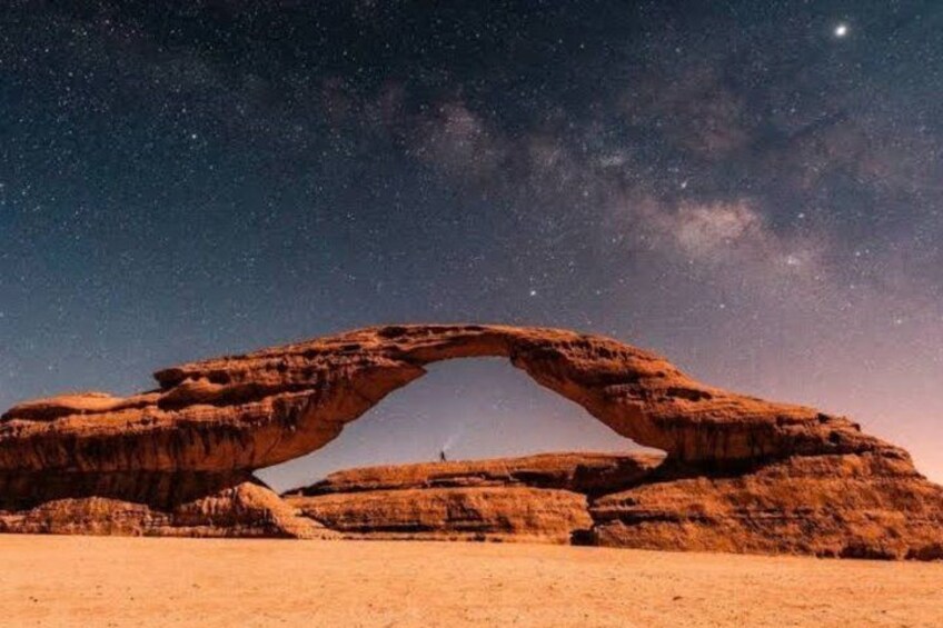 A rock arch formation under a starry night sky. 5