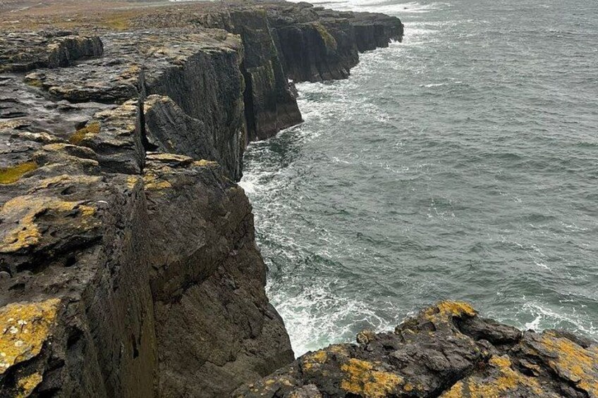 A rugged coastline with steep cliffs and rough sea waves crashing against the rocks. 5