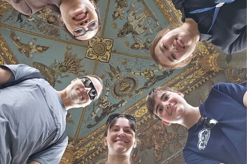 A group of people looking up at a ceiling with intricate patterns and designs. 4