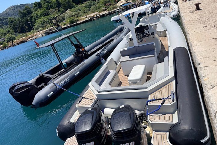 A boat docked at a pier with a small inflatable boat attached to it. 3
