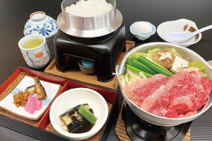 A hot pot setup with various ingredients like meat, vegetables, and tofu. 2