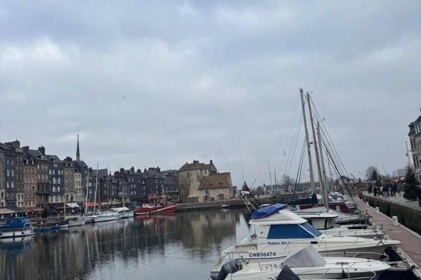A harbor with boats docked, a castle, and historic buildings along the waterfront. 1