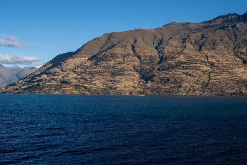 A mountainous landscape with a body of water in the foreground. 4