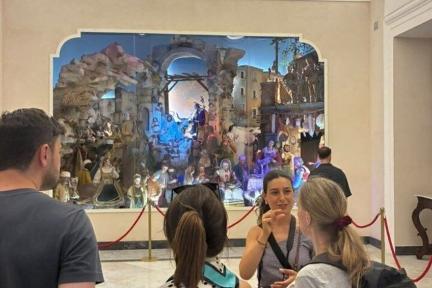 A group of people observing a historical scene in a museum. 1