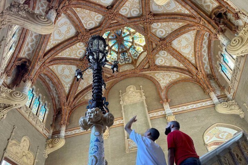 An ornate ceiling with intricate patterns and a large stained glass window. 4