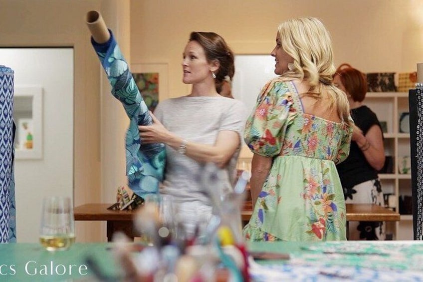 A person holding a rolled-up item, possibly a blanket or towel, in a room with a table and chairs. 4