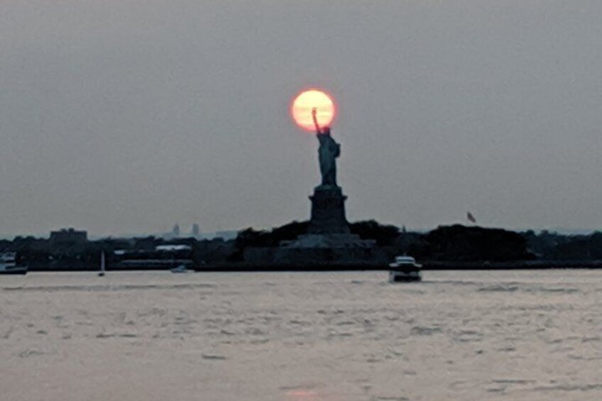 The Statue of Liberty with the sun setting behind it. 3