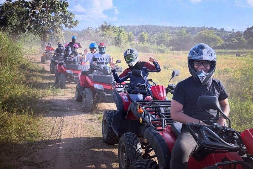 Un grupo de personas en cuatrimotos rojas sobre un sendero de tierra en una zona con césped. 5