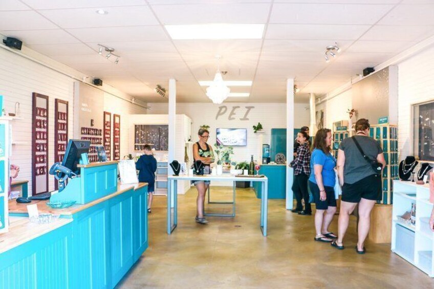 A shoe store interior with a counter, shelves, and a few customers. 2