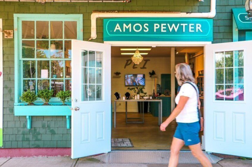 A storefront with a teal sign reading 'AMOS PEWTER' and a woman walking in front. 3