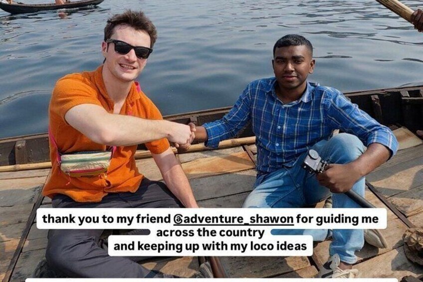 Two people on a boat, one in an orange shirt and the other in a blue shirt, with a body of water in the background. 2