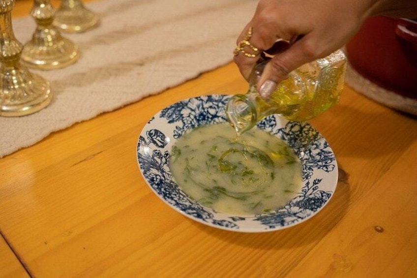 A hand pouring a yellow liquid into a bowl with a blue floral pattern. 4