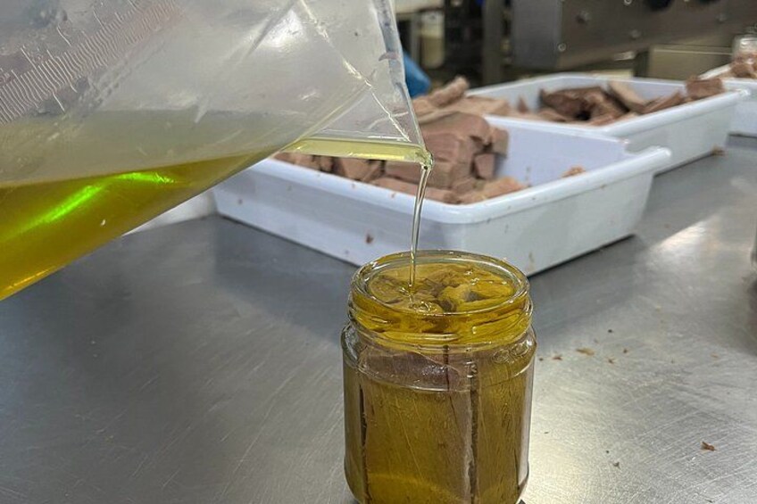 A person pouring a yellow liquid into a glass jar. 5