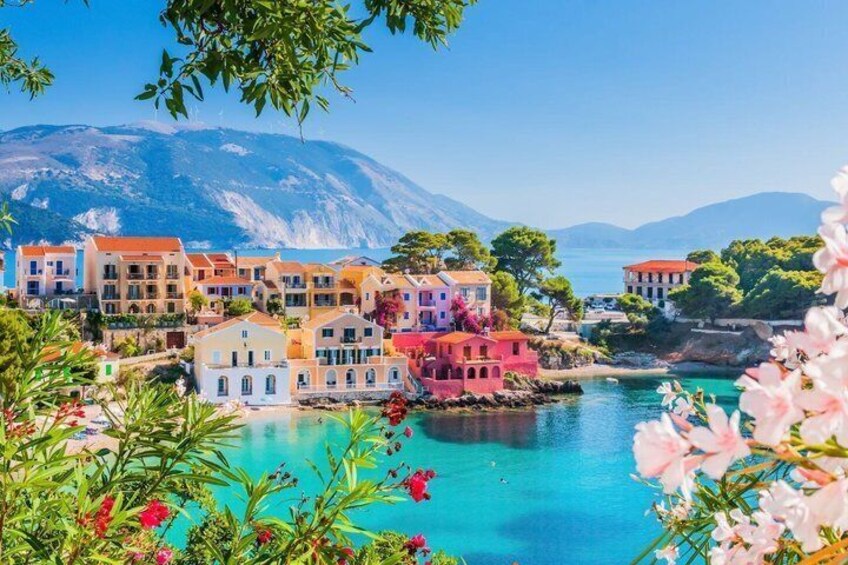 A coastal village with colorful buildings, a turquoise sea, and a mountain in the background. 5