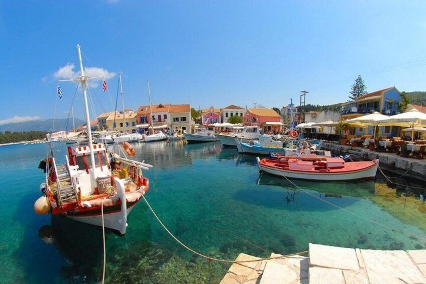 A marina with boats, clear water, and colorful buildings. 3