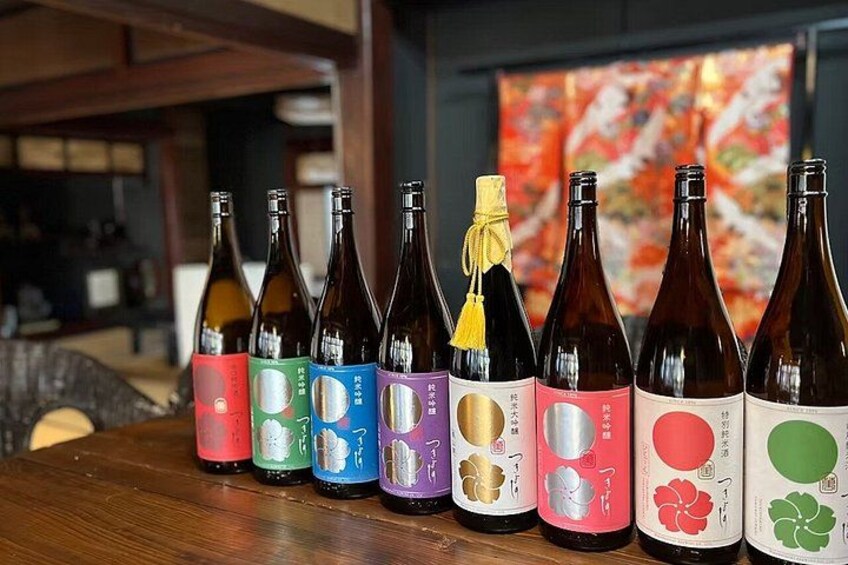 A row of bottles with colorful labels on a wooden table. 5
