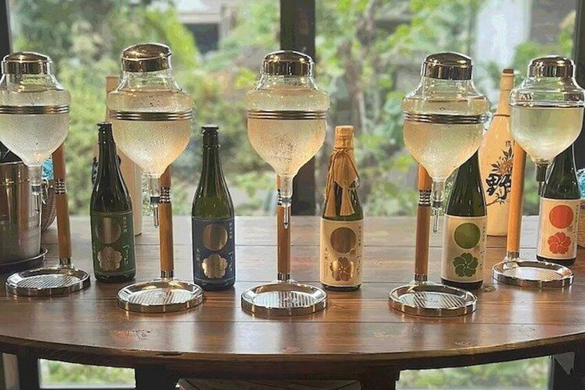 A wooden table with various bottles and glasses. 4