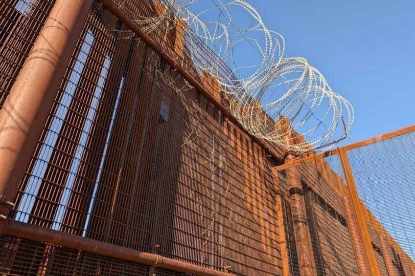 A metal fence with barbed wire. 1