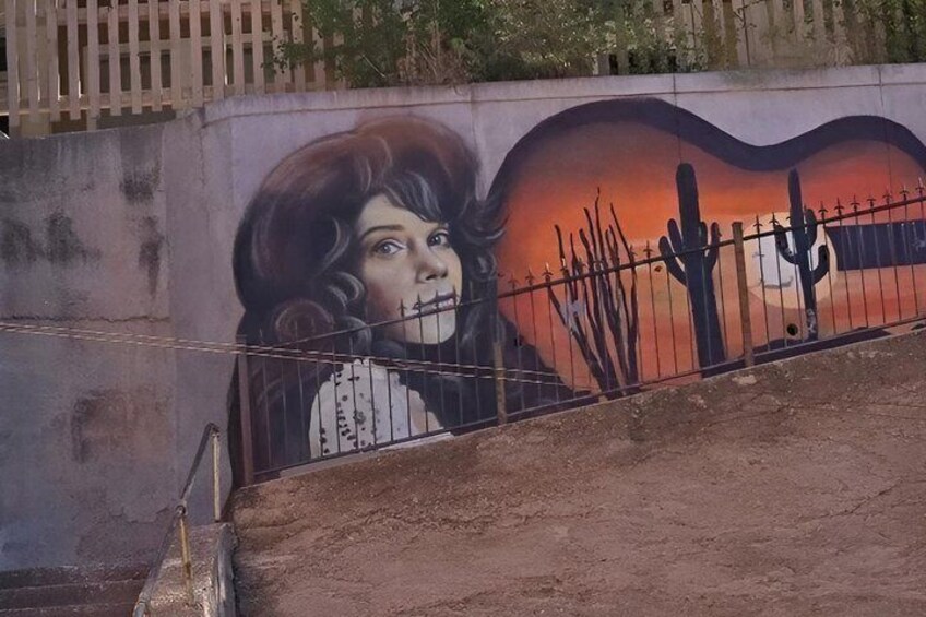 A mural on a wall with a desert landscape and a cactus. 4