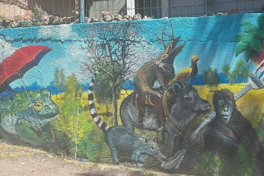 A mural with animals and a tree. 3